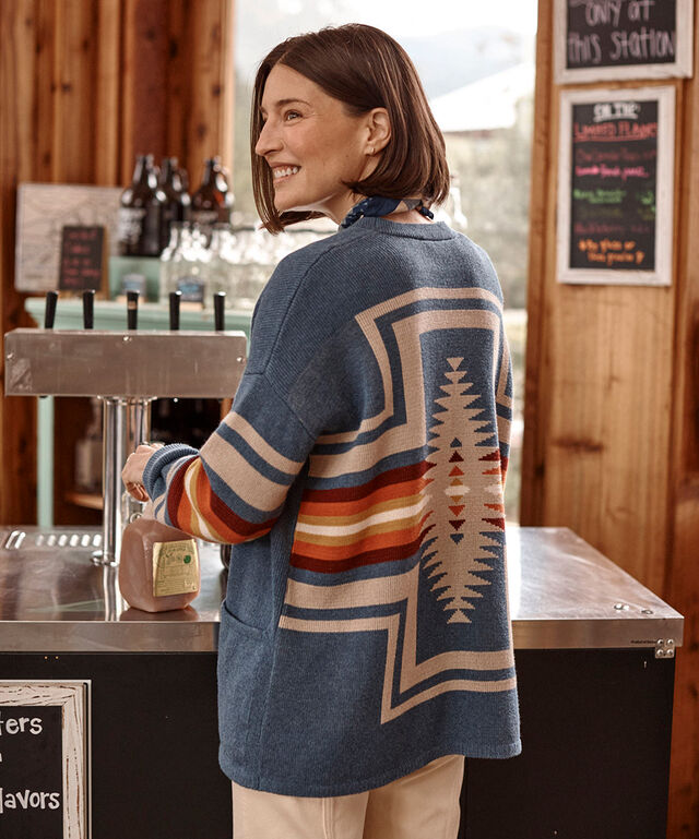 Woman standing in a cafe wearing a Pendleton Sweater