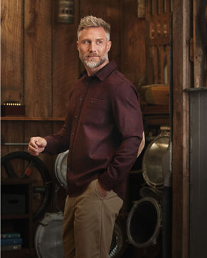 Man standing in barn wearing an Elbow-Patch Trail Shirt